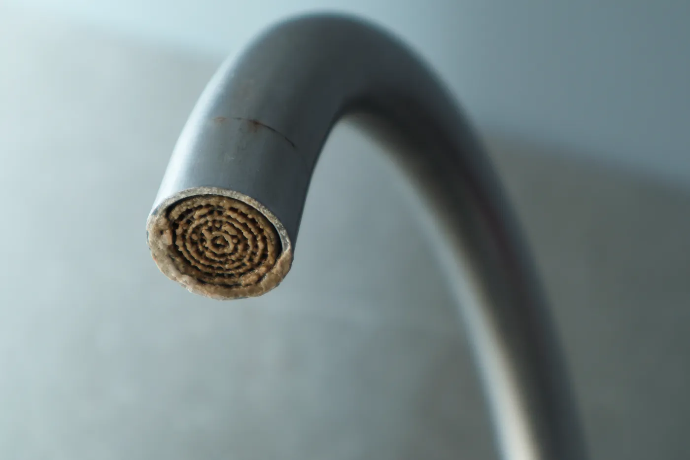 Cal acumulada en el aireador de un grifo por el agua dura