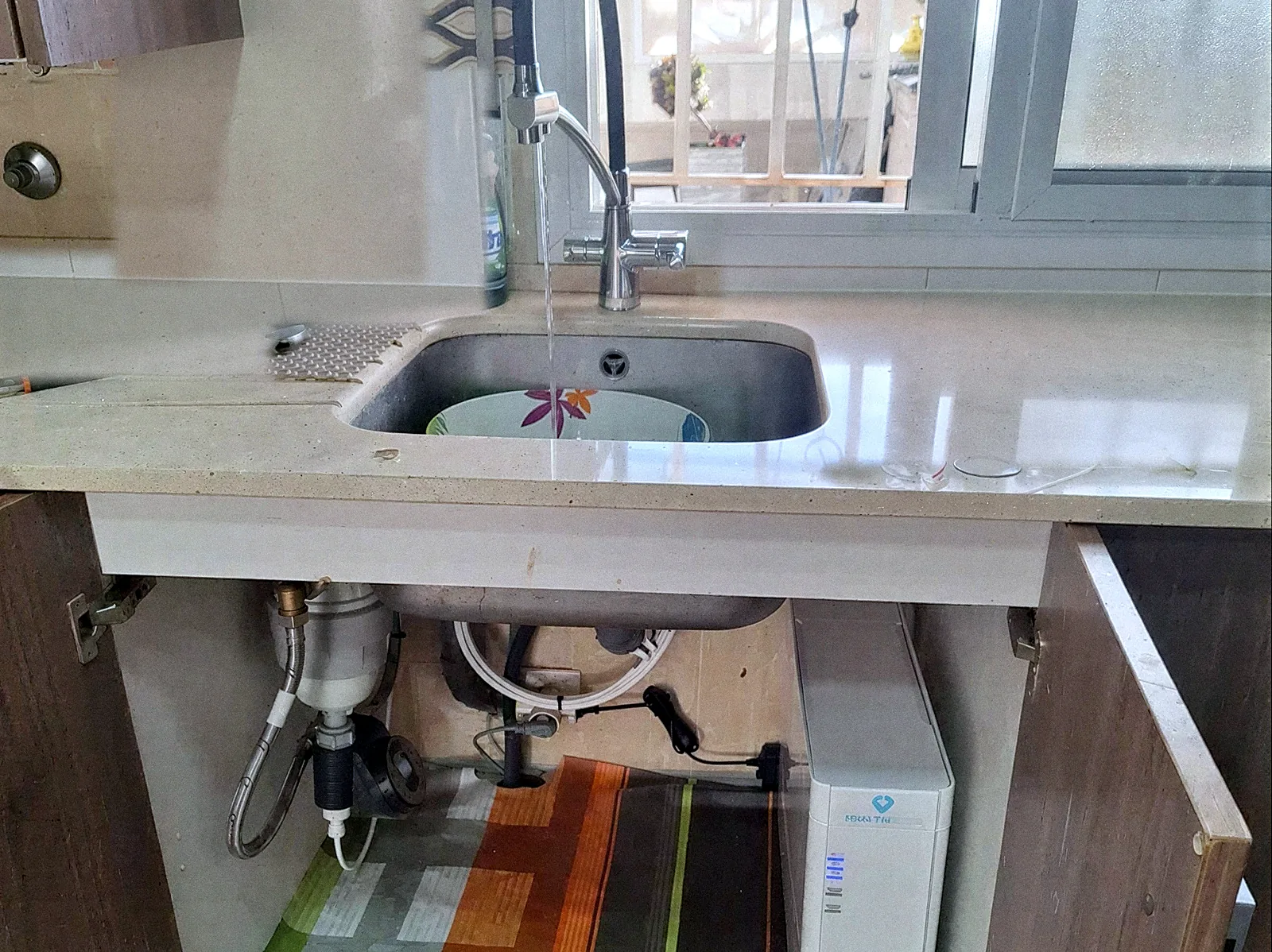 Equip Genesis instal·lat sota la pica d'una cuina, amb filtre i equip d'osmosi