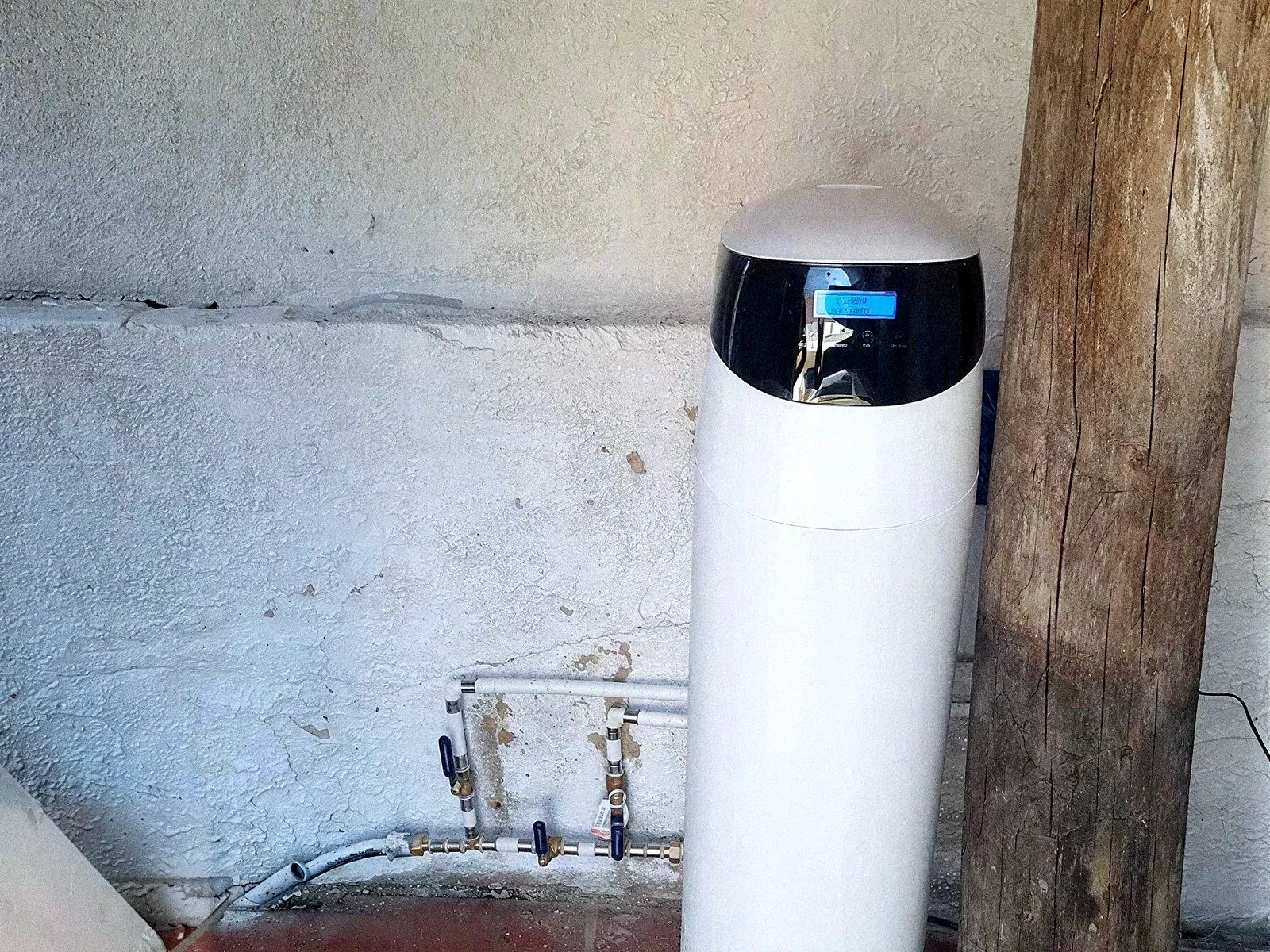 Descalcificador VD de columna al costat de l'escomesa d'aigua en un magatzem