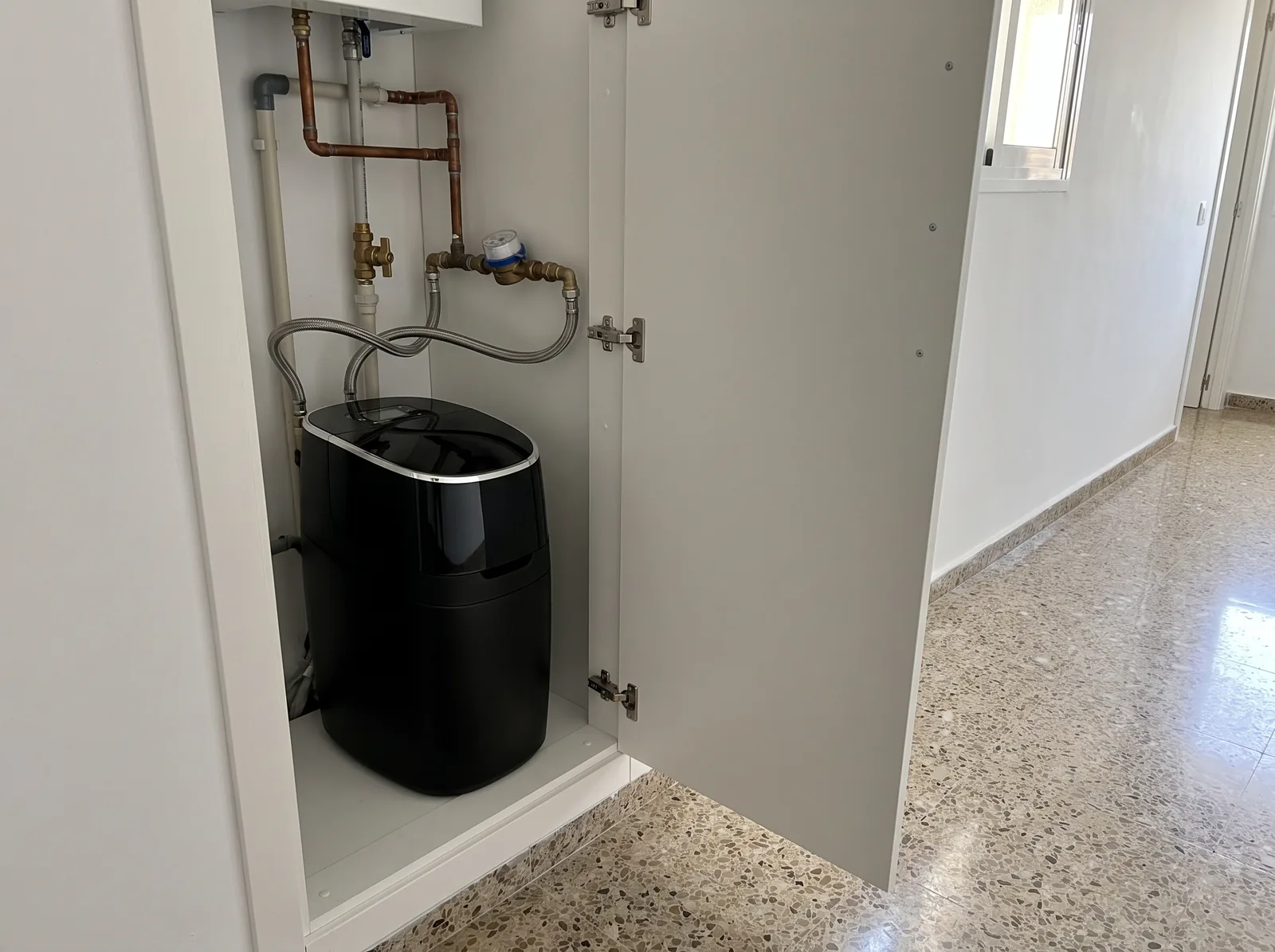 Il·lustració: Pure Black dins de l'armari d'instal·lacions del passadís, connectat al costat del comptador d'aigua
