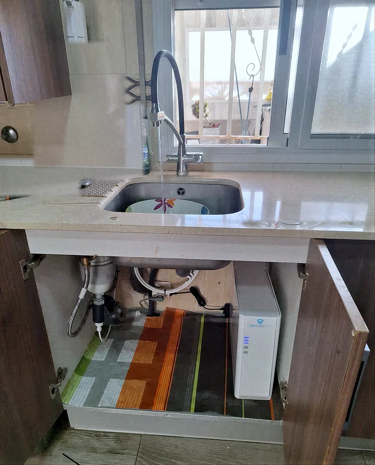 Equip Genesis instal·lat sota la pica d'una cuina, amb filtre i equip d'osmosi