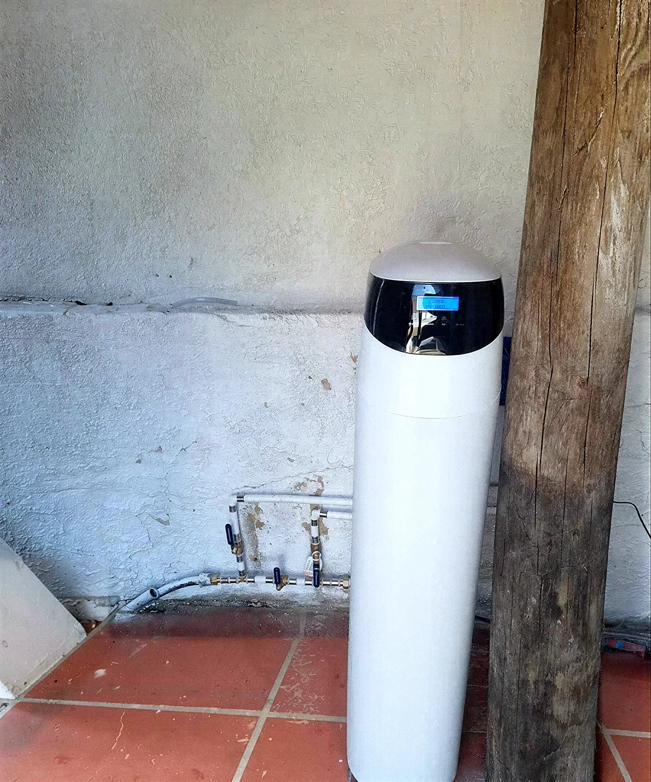 Descalcificador VD de columna al costat de l'escomesa d'aigua en un magatzem