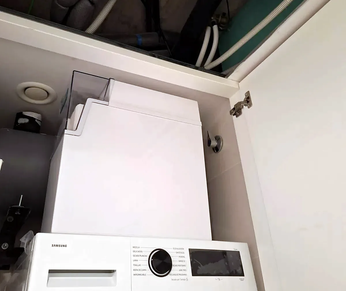 Descalcificador Dualflo instal·lat en un armari tècnic al costat de la rentadora