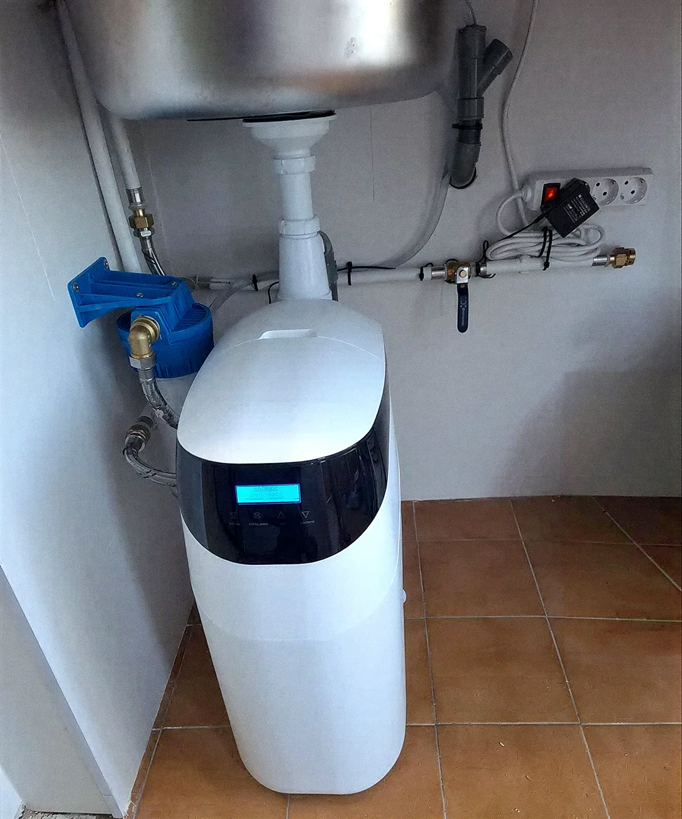 Descalcificador VD amb filtre blau instal·lat sota una pica de safareig