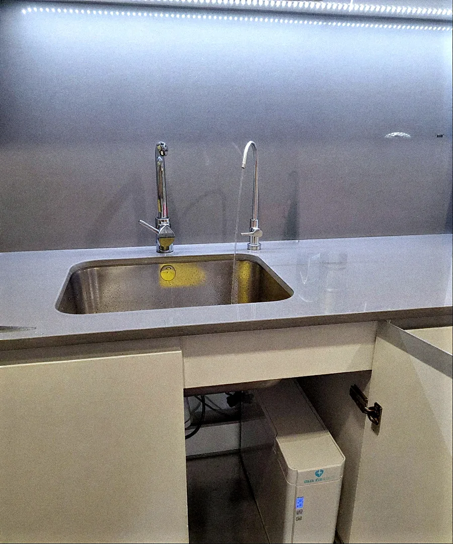 Cuina amb aixeta d'osmosi al costat de l'aixeta principal i equip Health Water sota la pica