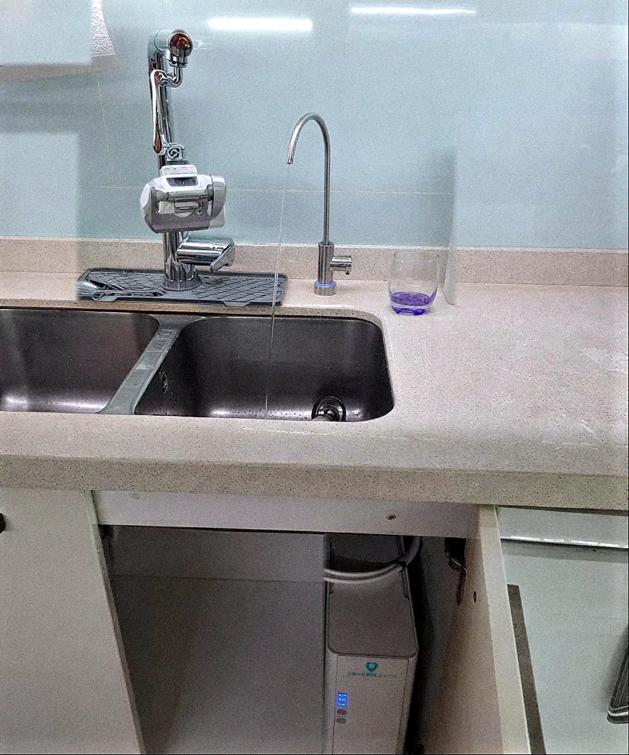Aixeta d'osmosi al costat de la pica i equip Health Water instal·lat a sota
